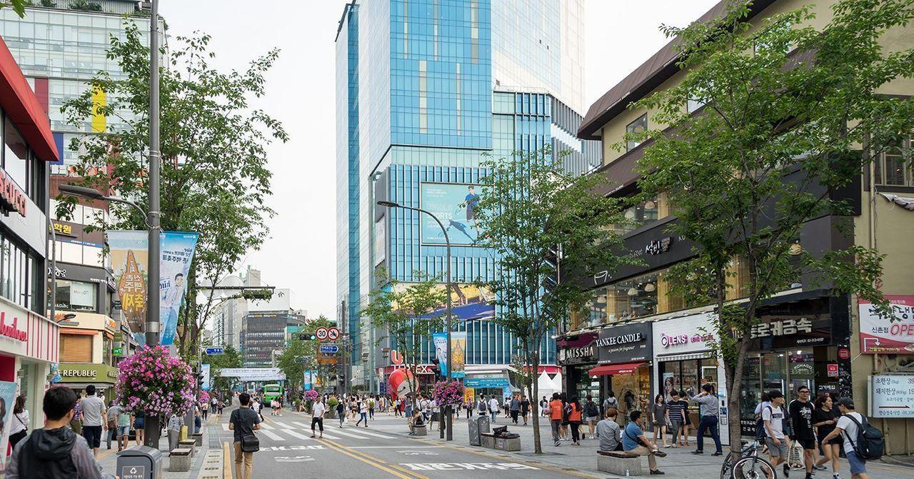 首爾新村商圈的購物指南，街道被購物者與行人填滿，展示活力市區